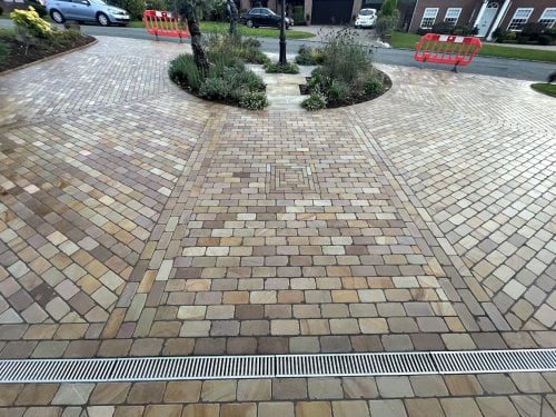 Wide view of a dry block paving driveway with vibrant natural color enhancement after treatment with HR Colour Enhancer sealer.
